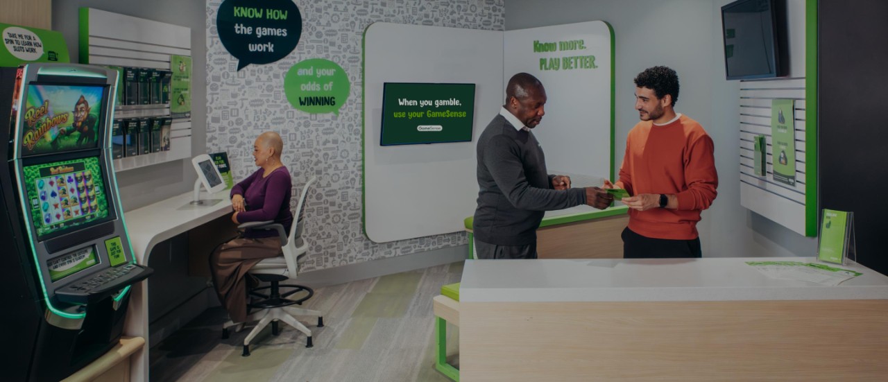 A GameSense Advisor talks with a player within a casino GameSense Info Centre.
